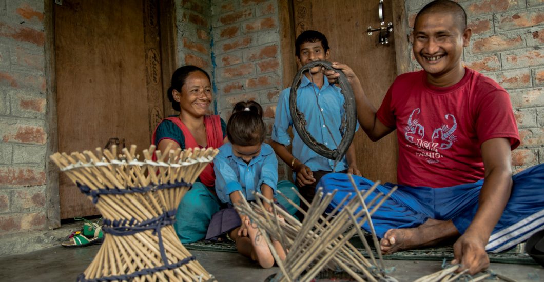 Person affected by leprosy Gobal making wooden stools to support his family